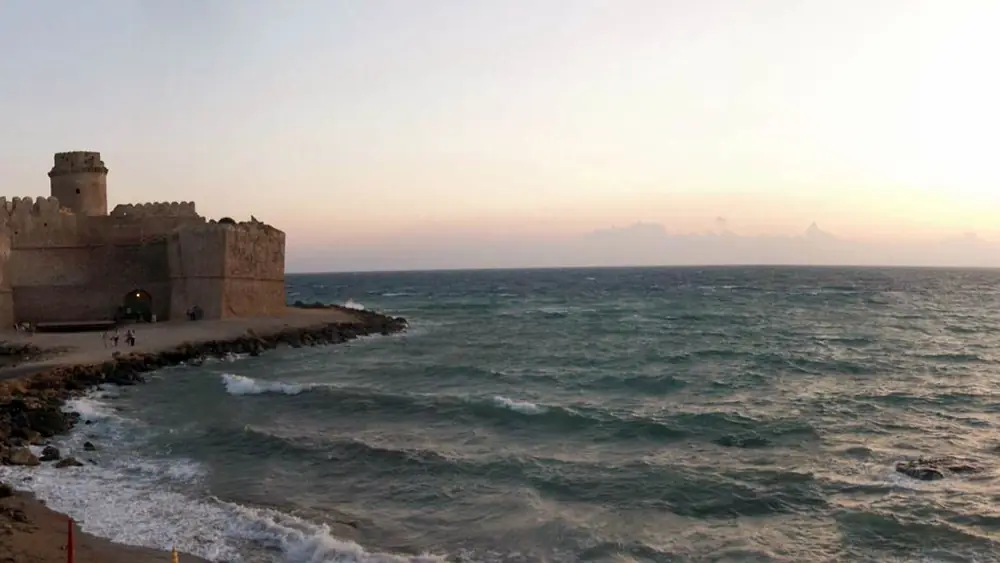 Castello sulla costa con mare in background