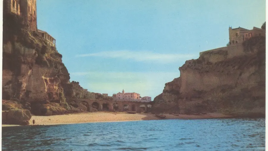Spiaggia di Tropea con case sulla roccia e mare blu