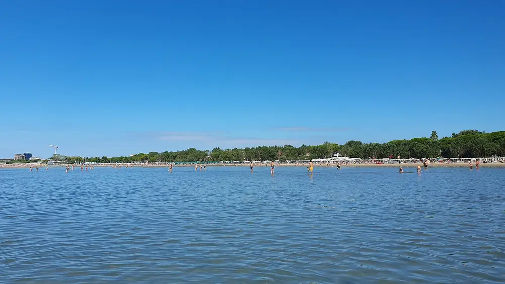 Spiaggia con persone che nuotano in acqua cristallina