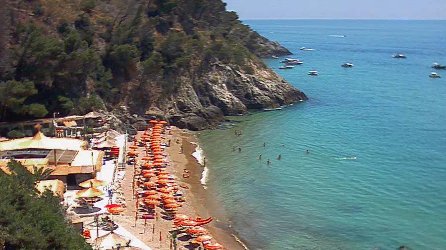 Spiaggia di Sperlonga con ombrelloni arancioni e acqua cristallina