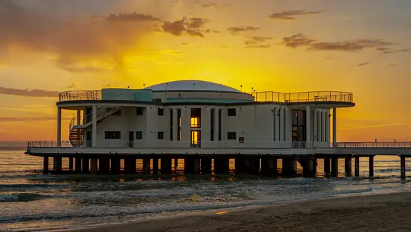 Un edificio circolare sul lungomare durante il tramonto.