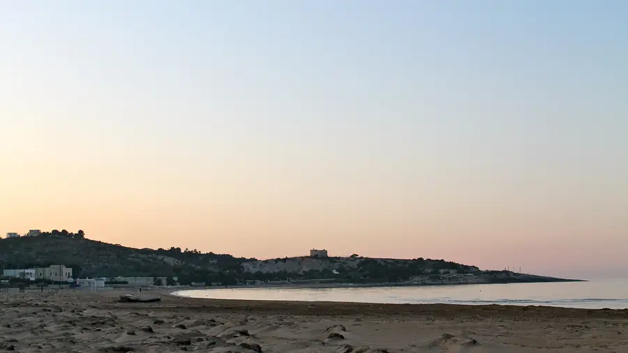 Spiaggia di Vieste durante il tramonto, con la costa e il mare in vista