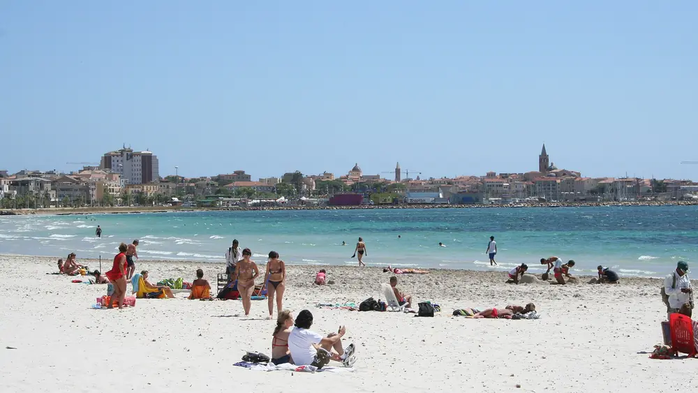 Spiaggia di Alghero con gente che si diverte e il mare cristallino