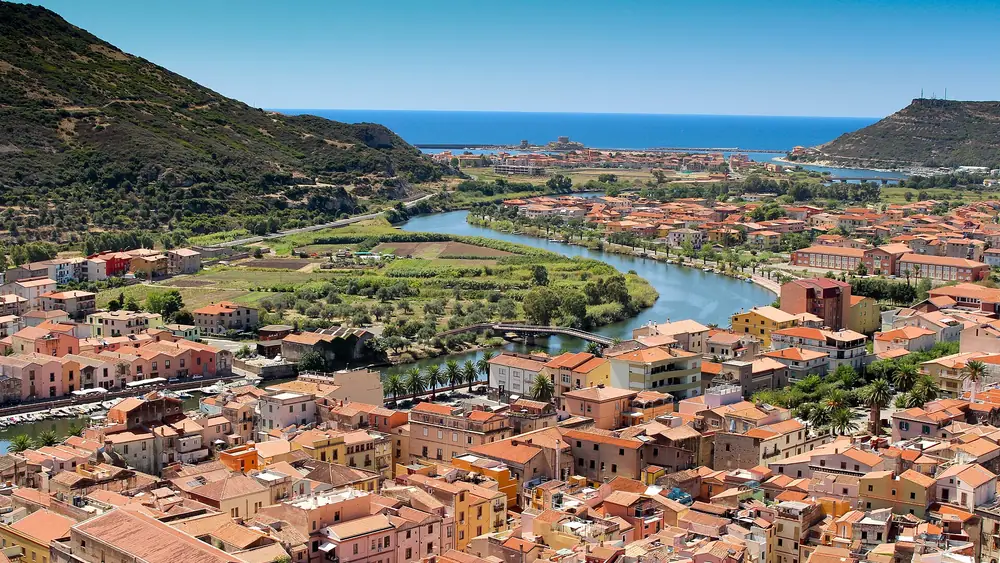 Vista panoramica di un piccolo villaggio costiero con case colorate e un fiume che scorre attraverso la città.