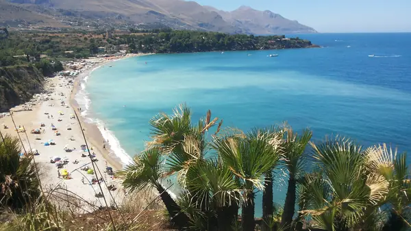 Spiaggia con palme e montagne sullo sfondo