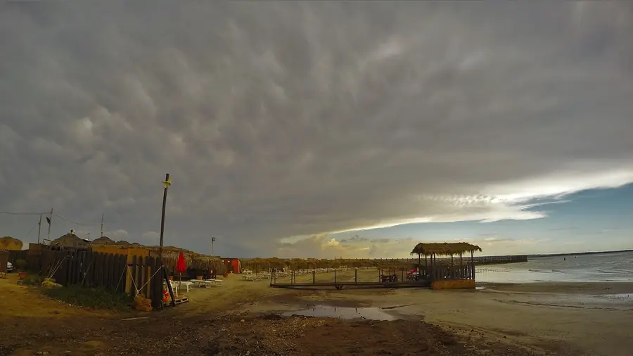 Spiaggia con tende di paglia e un cielo nuvoloso