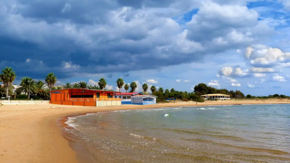 Spiaggia con palme e edifici colorati