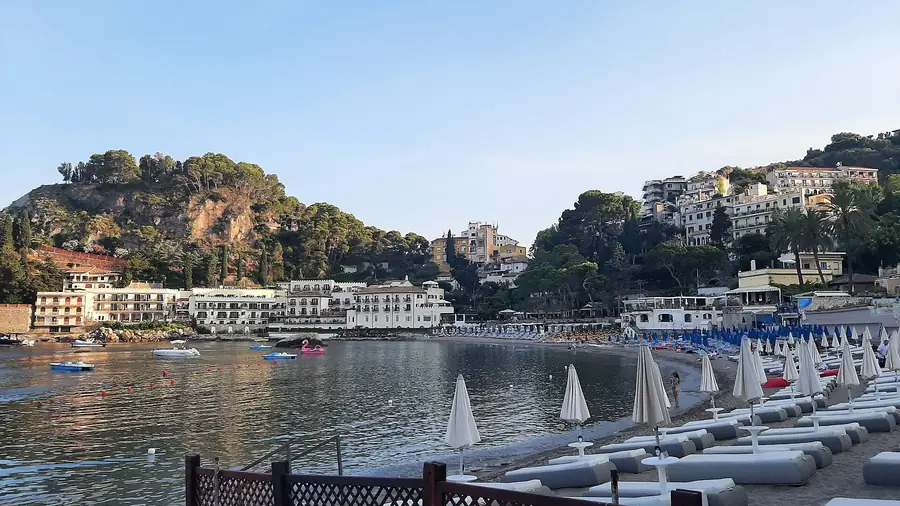 Spiaggia di Taormina con barche e case sullo sfondo
